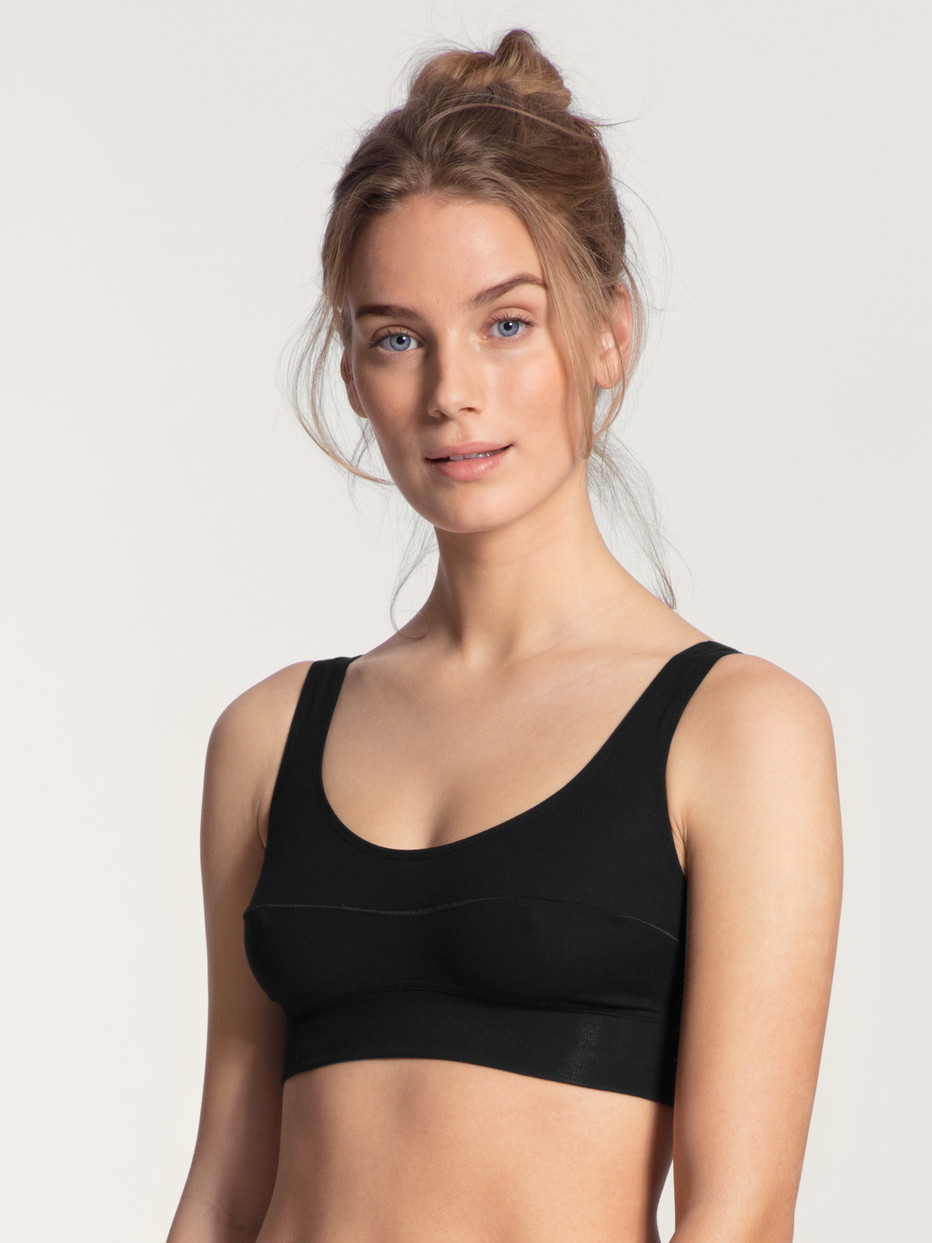 Damen-Model trägt Bustier mit Softbund aus Baumwolle in Schwarz, Einfarbig aus Serie Elastic von CALIDA, Vorderansicht