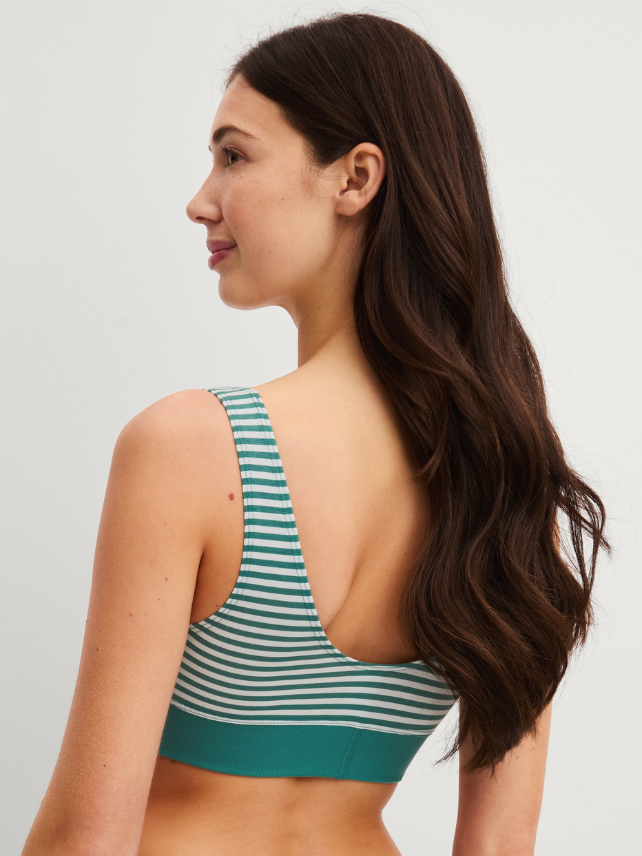 Damen-Model trägt Bustier mit Softbund aus Baumwolle in Grün, Gestreift aus Serie Elastic Special von CALIDA, Rückansicht