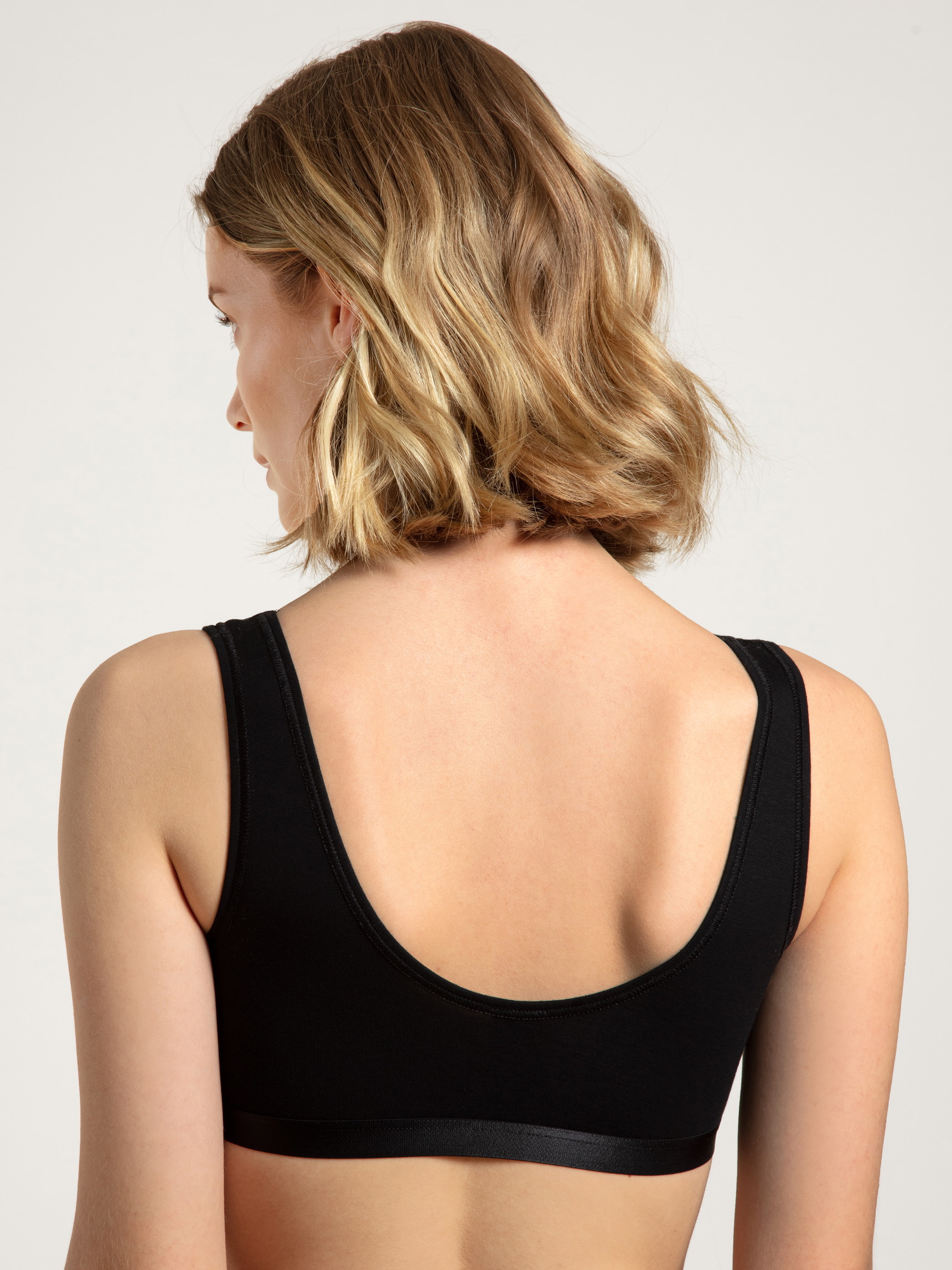 Damen-Model trägt Bustier, 2er-Pack aus Baumwolle in Schwarz, Einfarbig aus Serie Benefit Women von CALIDA, Rückansicht