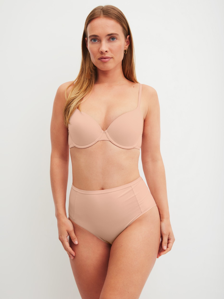 Damen-Model trägt Schalen-BH mit variablen Trägern aus Polyamid in Beige, Einfarbig aus Serie Sleek Skin von CALIDA, Outfit