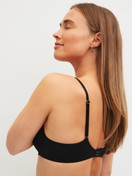 Women model is wearing Moulded Bra with Multiway Straps made of Polyamide in Black, Unicoloured from the Sleek Skin series by CALIDA, Back view