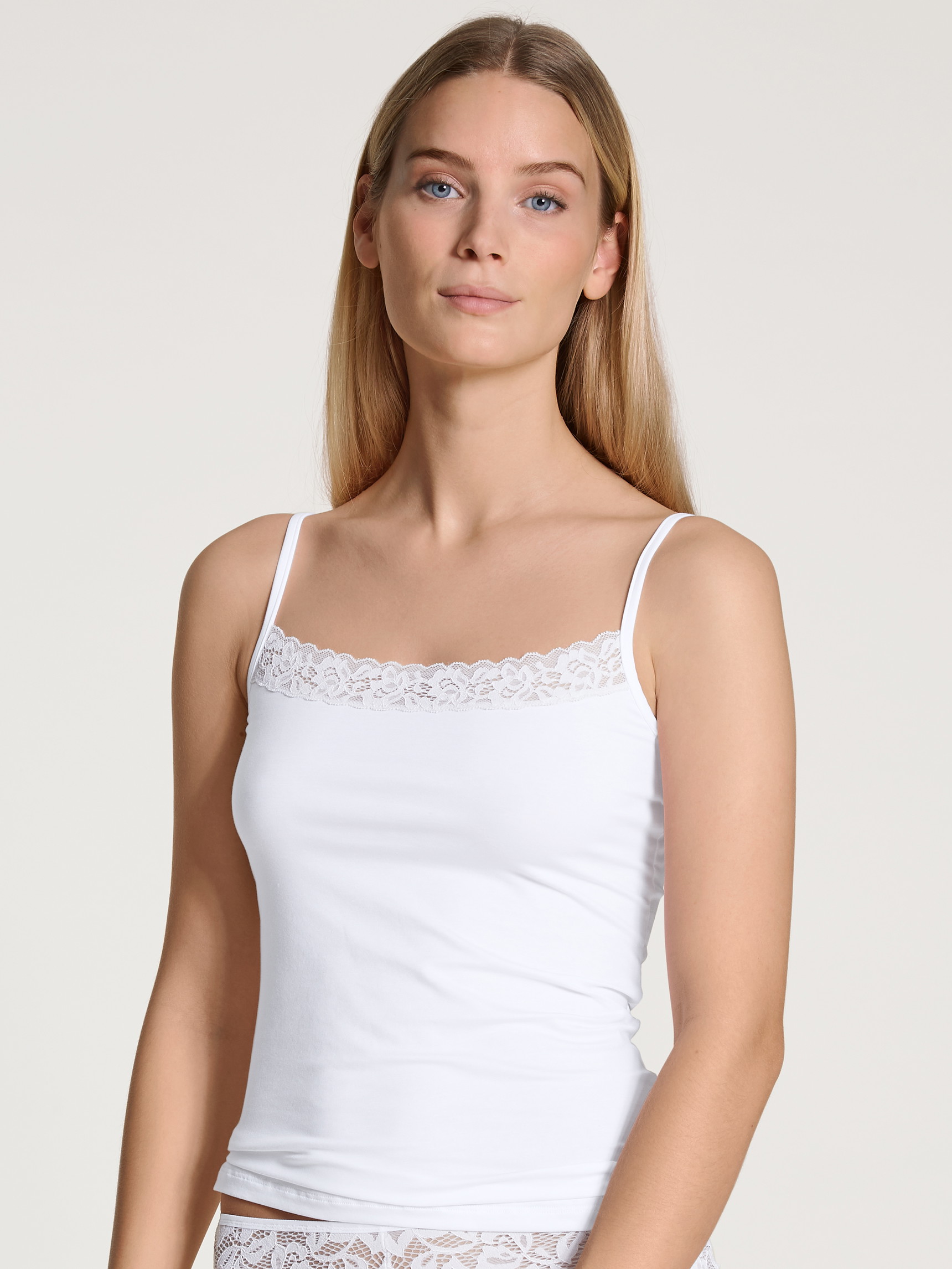 La modella / Il modello Donna indossa Top con spalline in Cotone di colore Bianco, Pizzo, della serie Natural Comfort Lace di CALIDA, Vista frontale