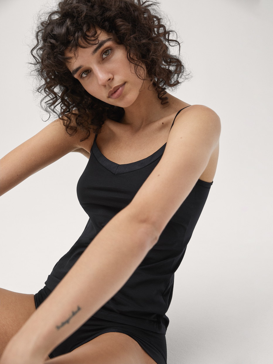 Damen-Model trägt Spaghetti-Top aus Baumwolle in Schwarz, Einfarbig aus Serie Cate von CALIDA, Vorderansicht