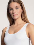 La modella / Il modello Donna indossa Tank top in 100% cotone di colore Bianco, Tinta unita, della serie Iconics di CALIDA, Dettaglio, Vista frontale