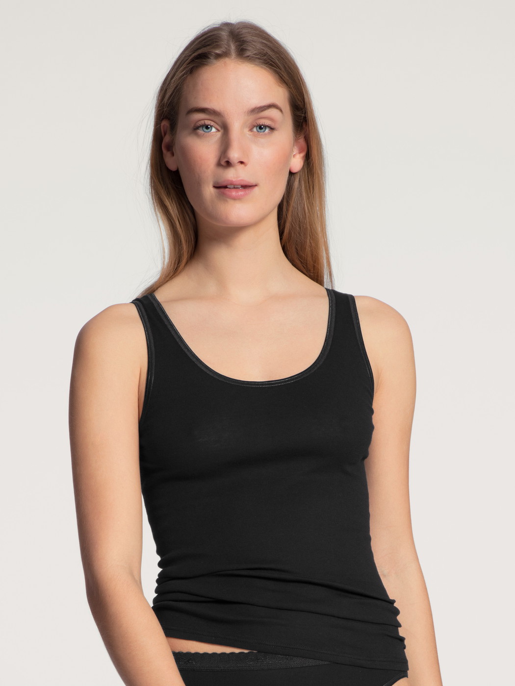 Women model is wearing Tank top made of 100% Cotton in Black, Unicoloured from the Iconics series by CALIDA, Front view
