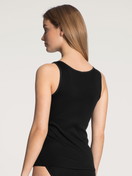 Women model is wearing Tank top made of 100% Cotton in Black, Unicoloured from the Iconics series by CALIDA, Back view