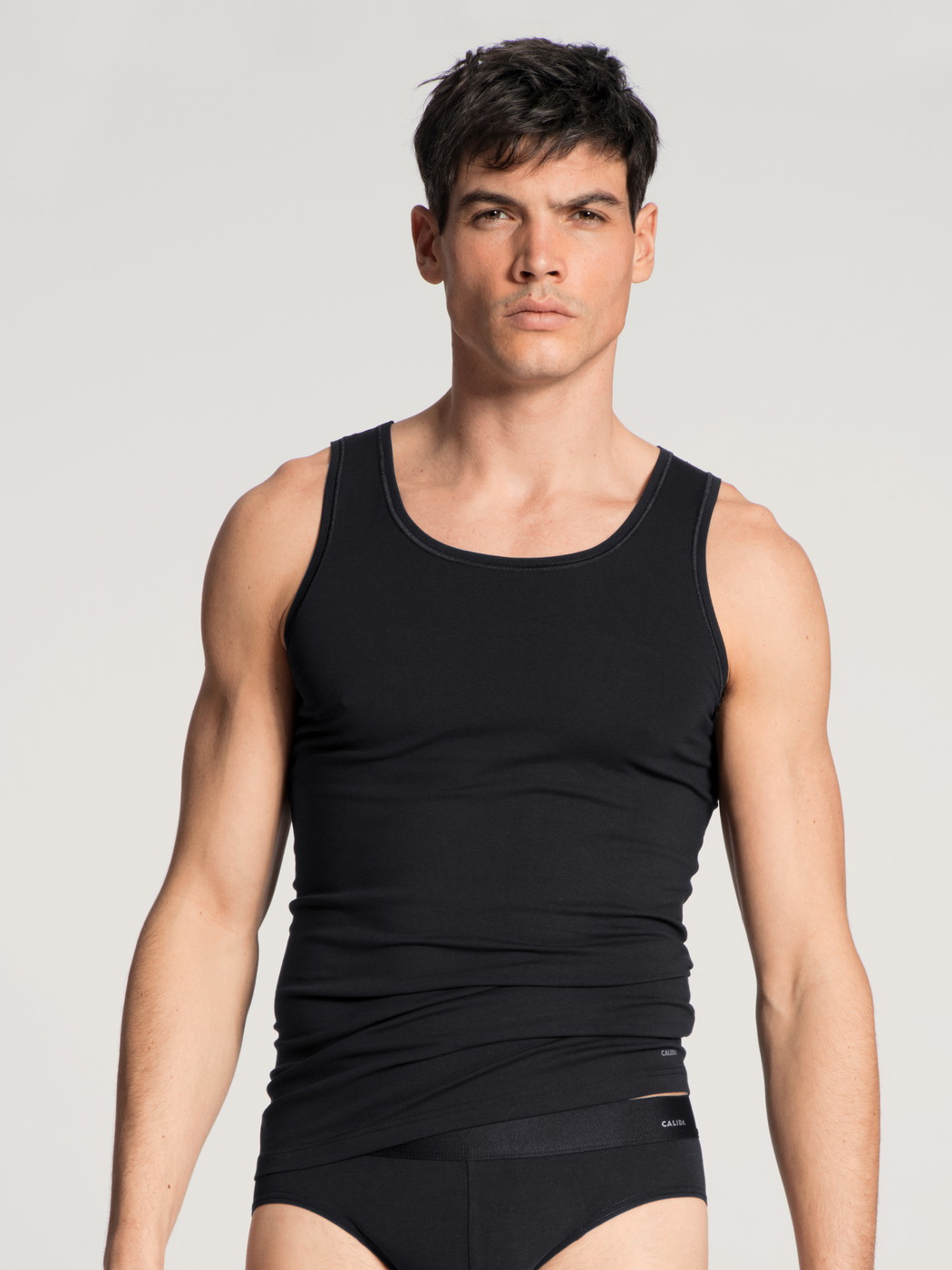 La modella / Il modello Uomo indossa Canottiera atletica in Cotone di colore Nero, Tinta unita, della serie Cotton Code di CALIDA, Vista frontale
