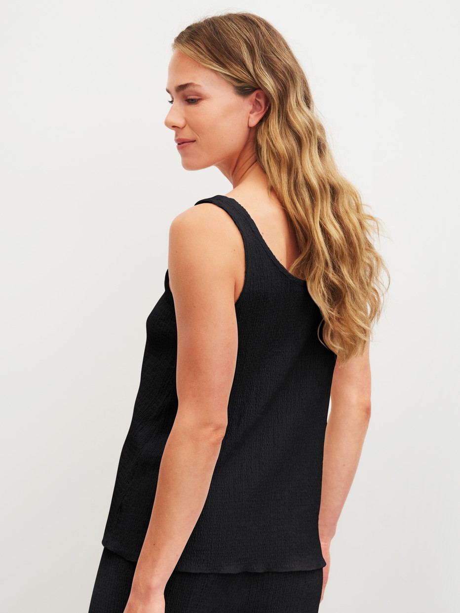 La modella / Il modello Donna indossa Tank top in Cotone di colore Nero, Tinta unita, della serie Favourites Layering di CALIDA, Vista posteriore