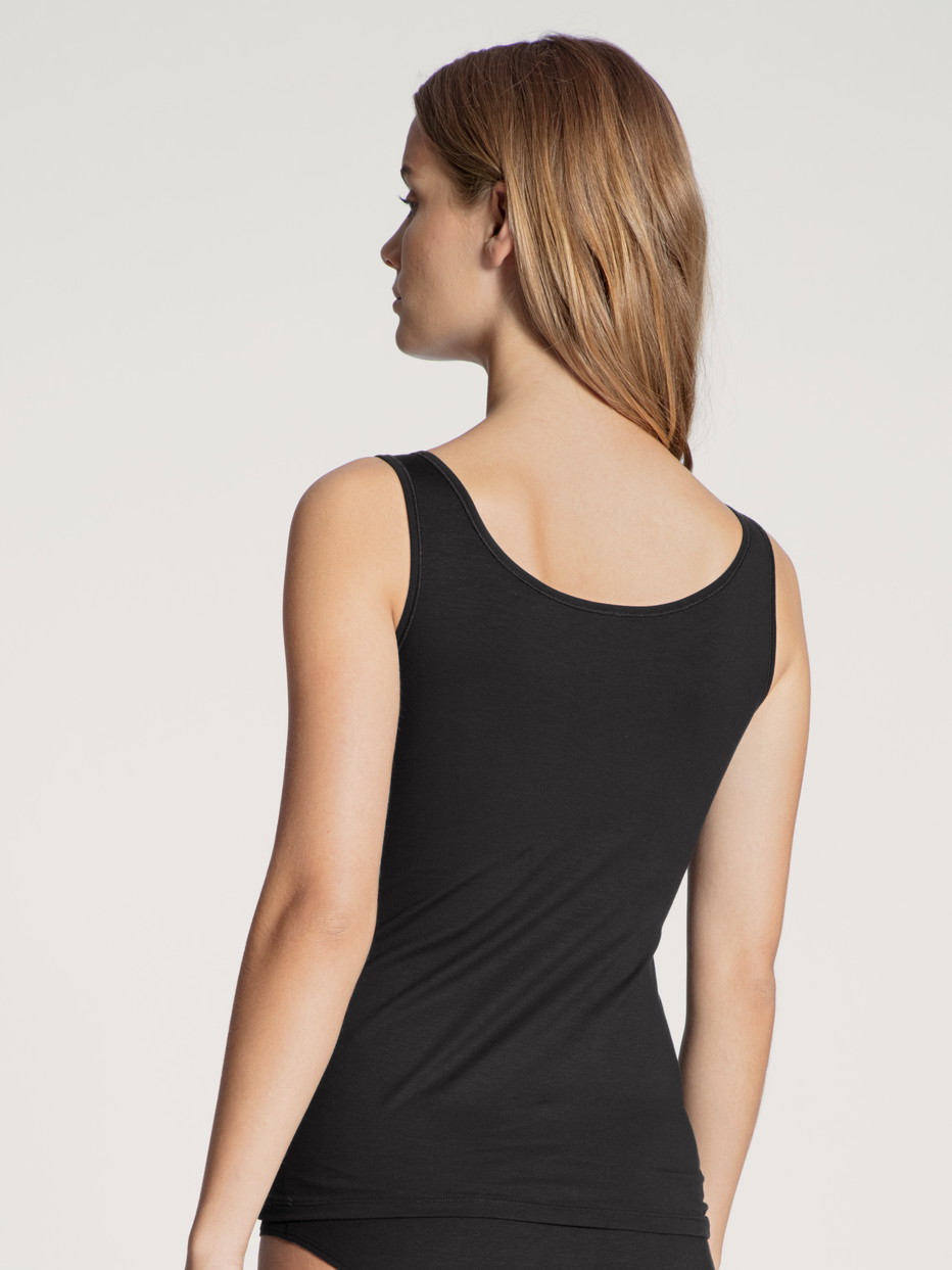 Damen-Model trägt Tank-Top aus Baumwolle in Schwarz, Einfarbig aus Serie Natural Comfort von CALIDA, Rückansicht