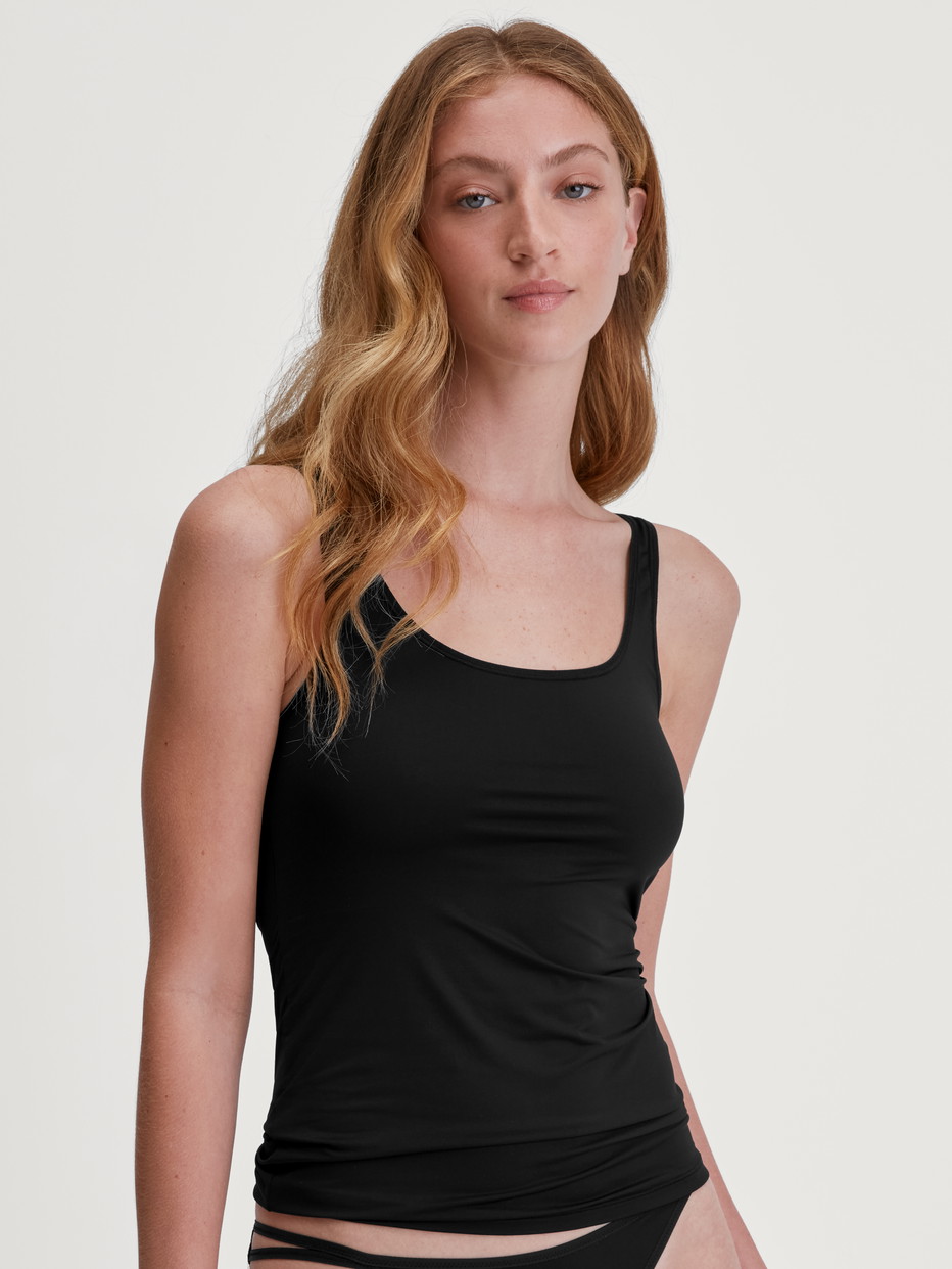 Damen-Model trägt Tank-Top aus Baumwolle in Schwarz, Einfarbig aus Serie Sleek Skin von CALIDA, Vorderansicht