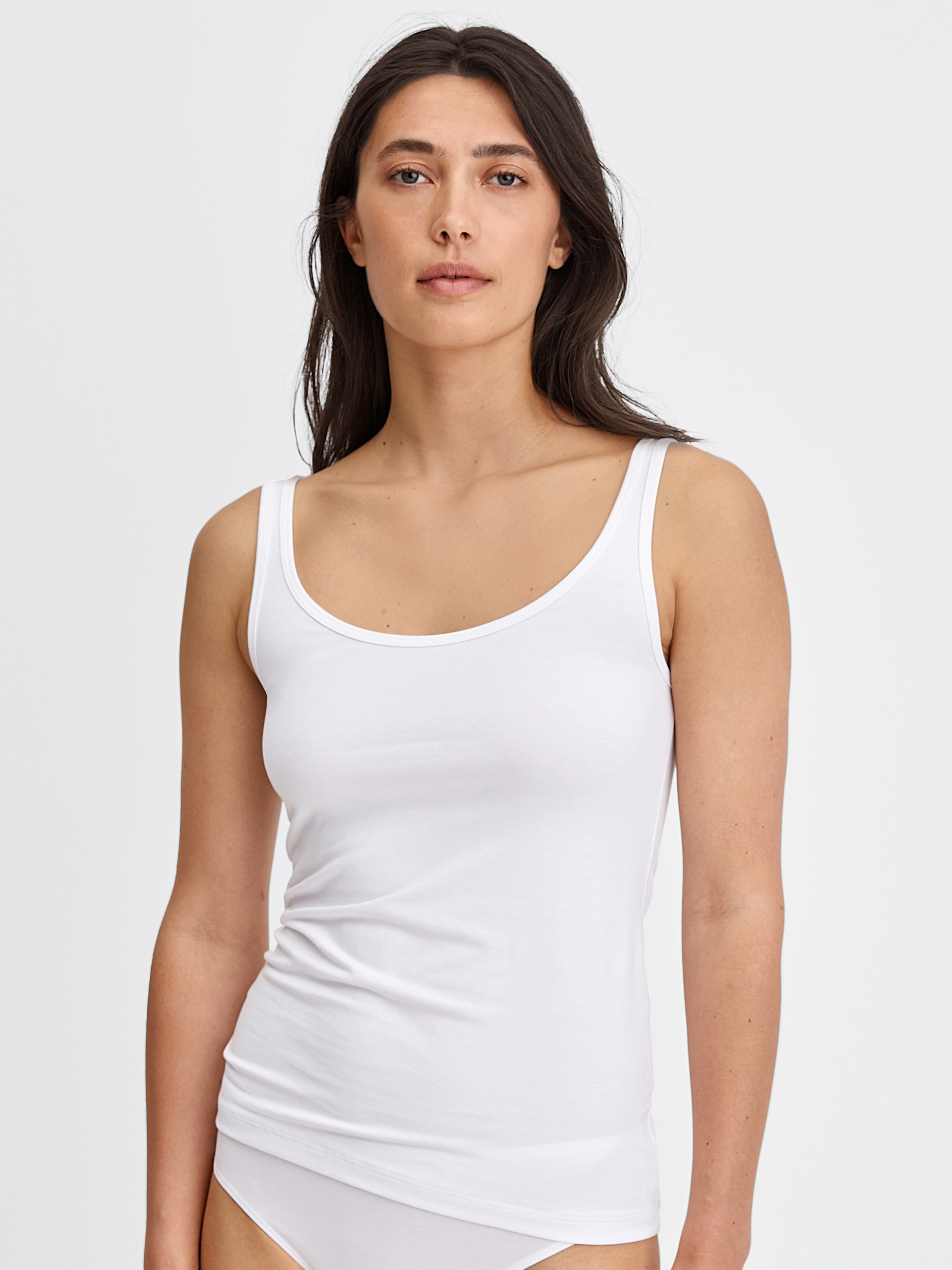 Women model is wearing Tank top made of Cotton in White, Unicoloured from the Essential Cotton series by CALIDA, Front view