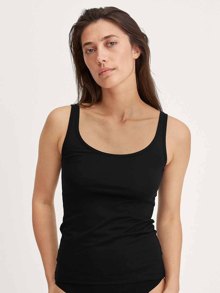 La modella / Il modello Donna indossa Tank top in Cotone di colore Nero, Tinta unita, della serie Essential Cotton di CALIDA, Vista frontale