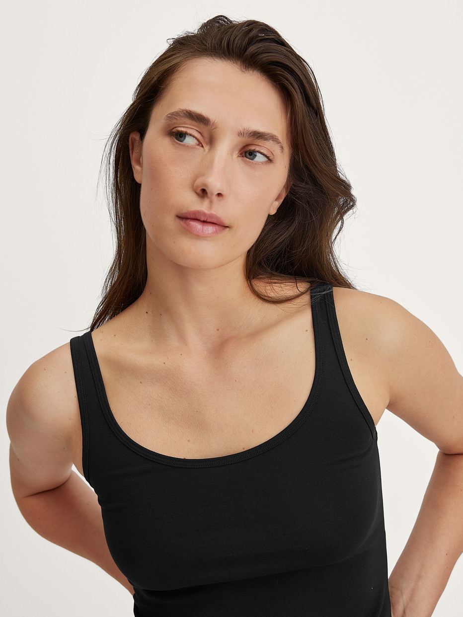 La modella / Il modello Donna indossa Tank top in Cotone di colore Nero, Tinta unita, della serie Essential Cotton di CALIDA, Dettaglio