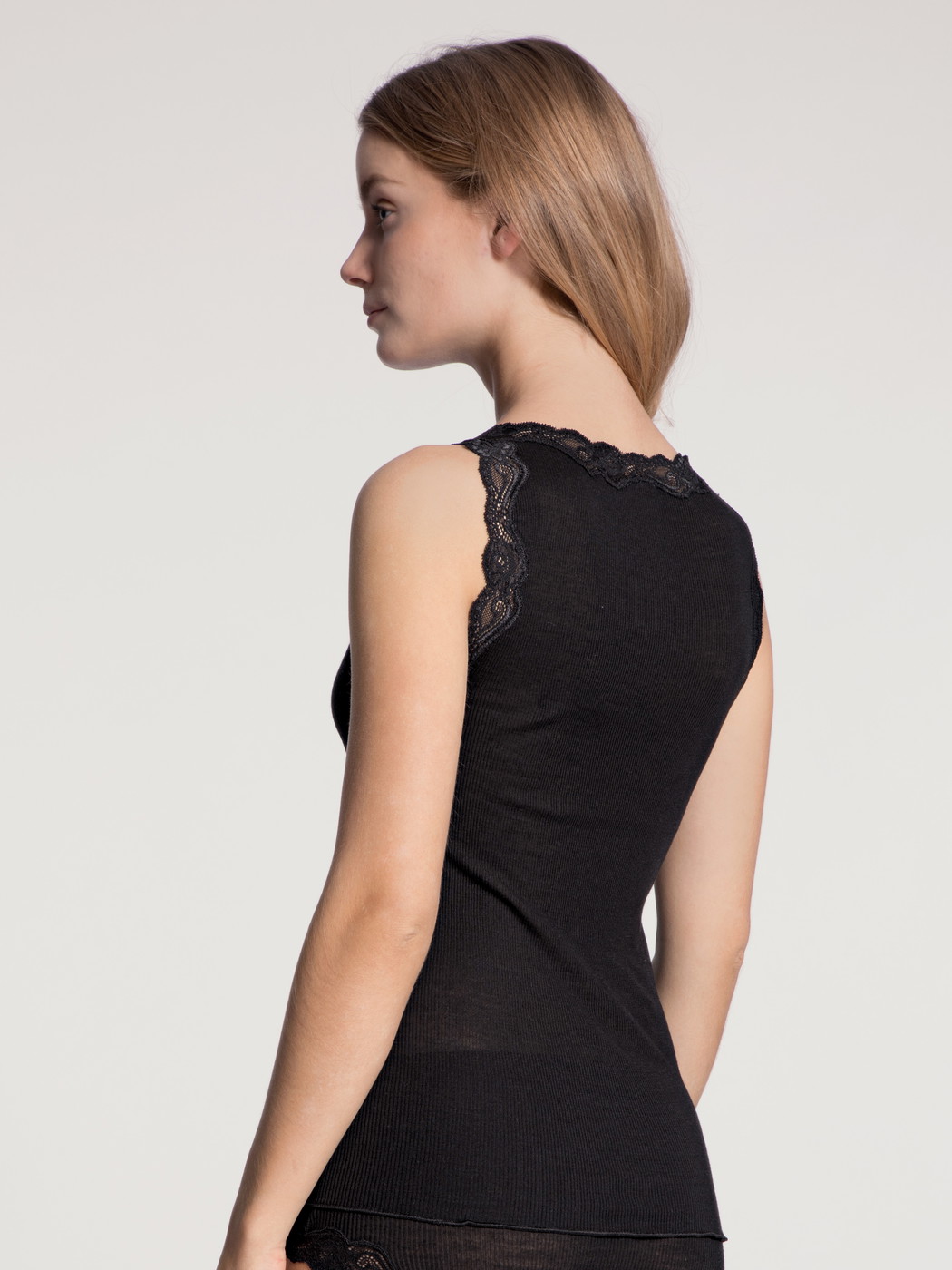Women model is wearing Tank top made of Wool in Black, Lace from the Richesse Lace series by CALIDA, Back view