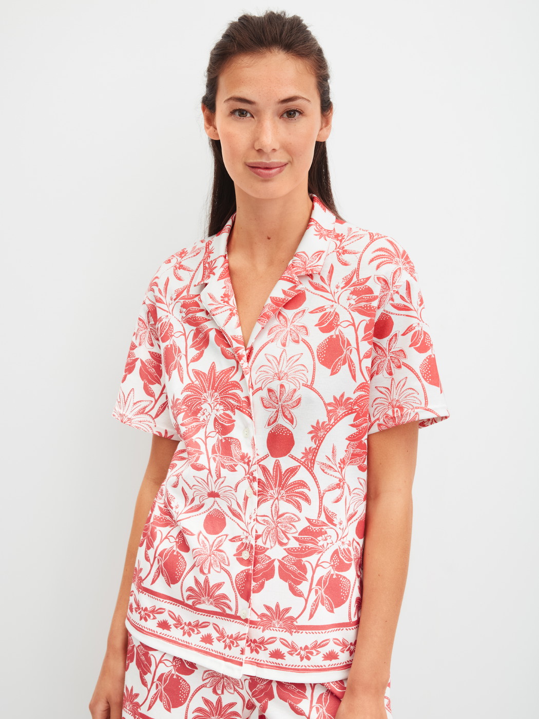 Women model is wearing Short-sleeved shirt with buttons made of 100% Cotton in Orange, Floral from the Favourites Beach series by CALIDA, Front view