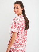 Women model is wearing Short-sleeved shirt with buttons made of 100% Cotton in Orange, Floral from the Favourites Beach series by CALIDA, Back view
