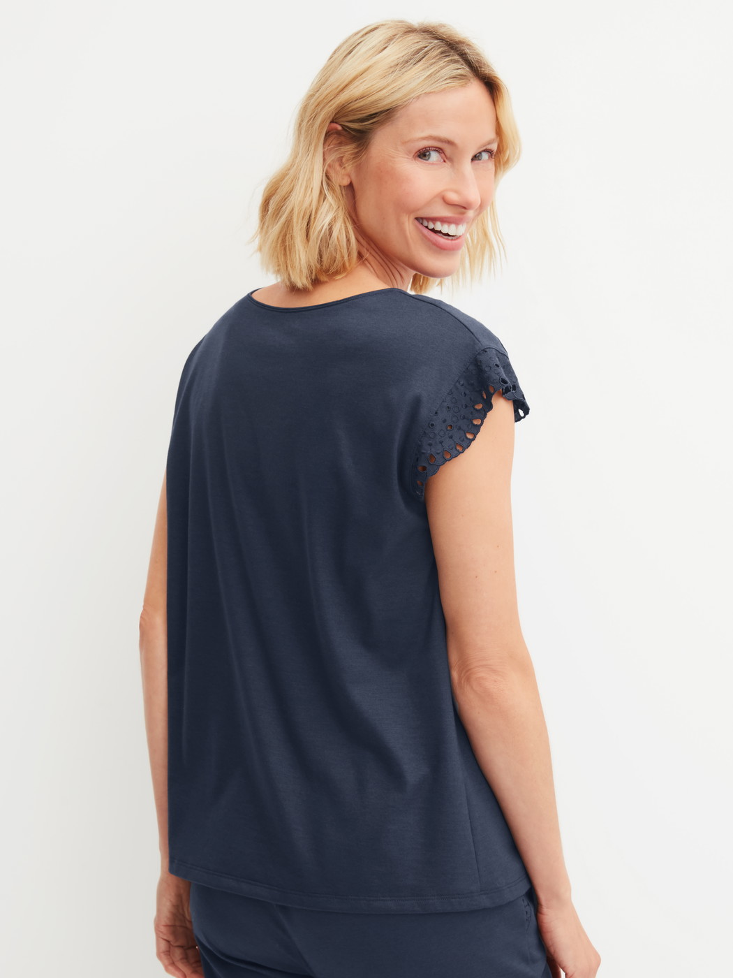 Damen-Model trägt Kurzarm-Shirt mit Flügelärmeln aus Baumwolle in Blau, Einfarbig aus Serie Favourites Tiles von CALIDA, Rückansicht