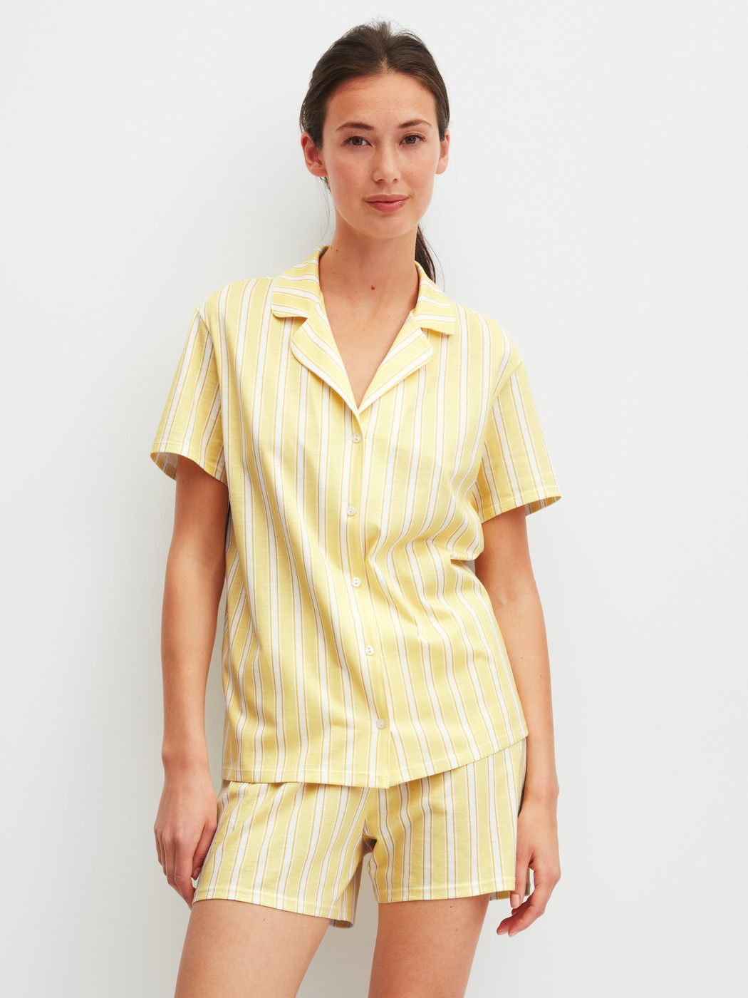 Women model is wearing Short-sleeved shirt with buttons made of 100% Cotton in Yellow, Striped from the Favourites Ocean series by CALIDA, Outfit