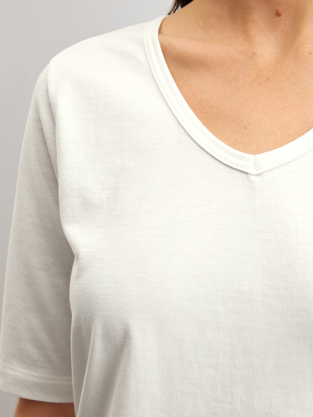 Le mannequin Femme porte le/la T-shirt à manches courtes et col en V en 100% coton de couleur Blanc, Unicolore, de la série Late Bloom M&M de CALIDA, Détail