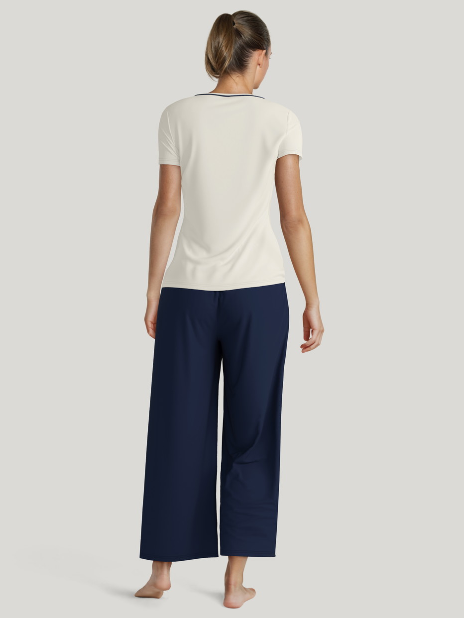 Damen-Model trägt Kurzarm-Shirt aus Lyocell in Weiß, Einfarbig aus Serie Favourites Xtra von CALIDA, Rückansicht, KI-generiertes Bild