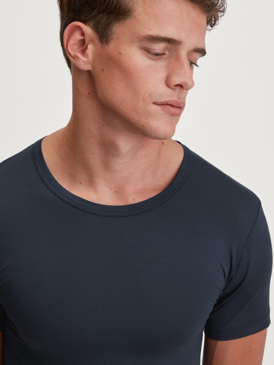 Herren-Model trägt Kurzarm-Shirt, Rundhals aus Modal in Blau, Einfarbig aus Serie Balanced Day von CALIDA, Detail