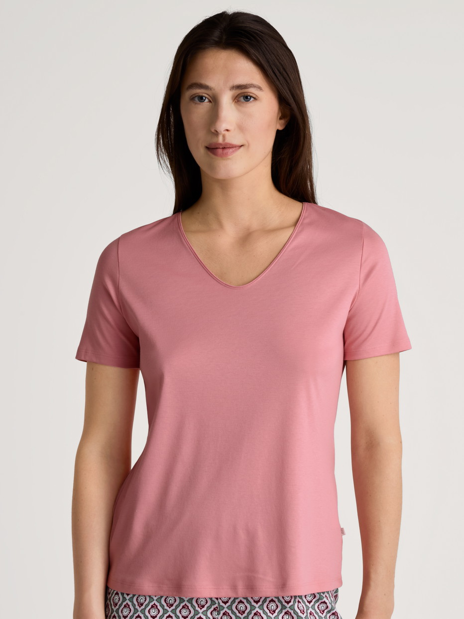 Damen-Model trägt Kurzarm-Shirt, V-Neck aus 100% Baumwolle in Rosa, Einfarbig aus Serie Favourites Ground von CALIDA, Vorderansicht
