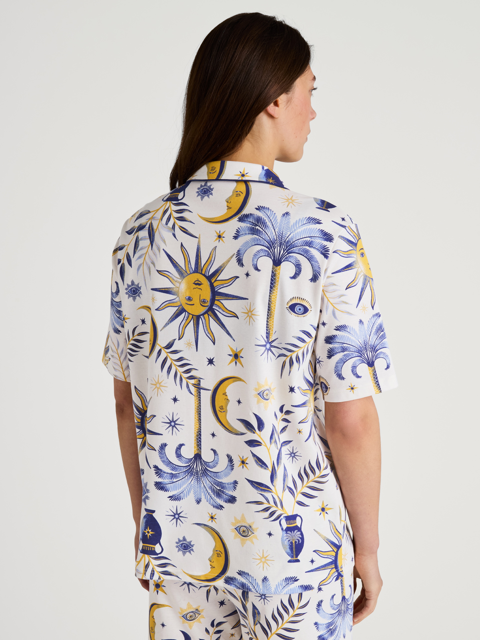 Damen-Model trägt Kurzarm-Shirt, durchgeknöpft aus 100% Baumwolle in Beige, Floral aus Serie Favourites Magic von CALIDA, Rückansicht