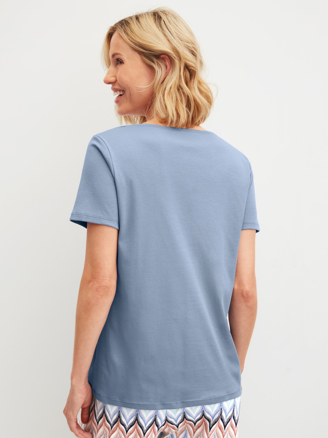 Women model is wearing Short-sleeved shirt made of 100% Cotton in Blue, Unicoloured from the Favourites Tiles series by CALIDA, Back view