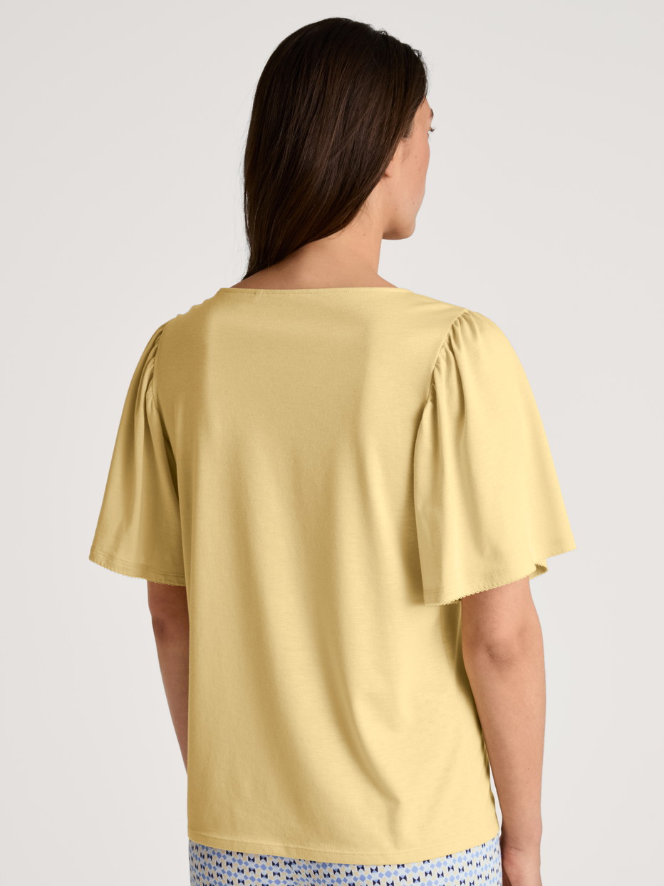 Damen-Model trägt Kurzarm-Shirt aus Modal in Gelb, Einfarbig aus Serie Favourites Joy von CALIDA, Rückansicht