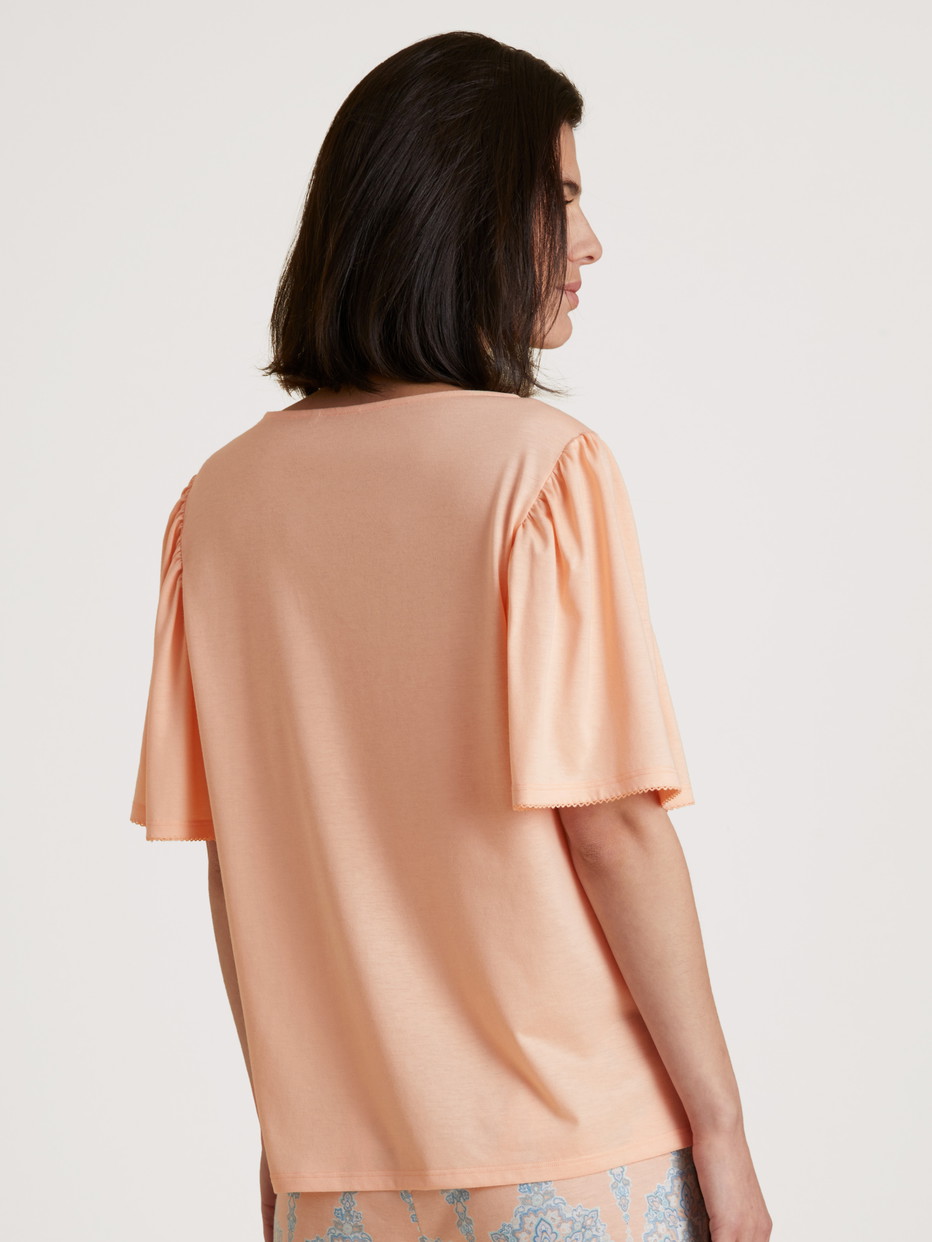 Damen-Model trägt Kurzarm-Shirt aus Modal in Orange, Einfarbig aus Serie Favourites Balance von CALIDA, Rückansicht