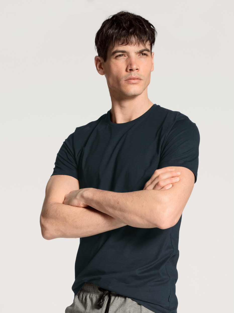 Herren-Model trägt Kurzarm-Shirt, Rundhals aus 100% Baumwolle in Blau, Einfarbig aus Serie Remix Basic Sleep von CALIDA, Vorderansicht