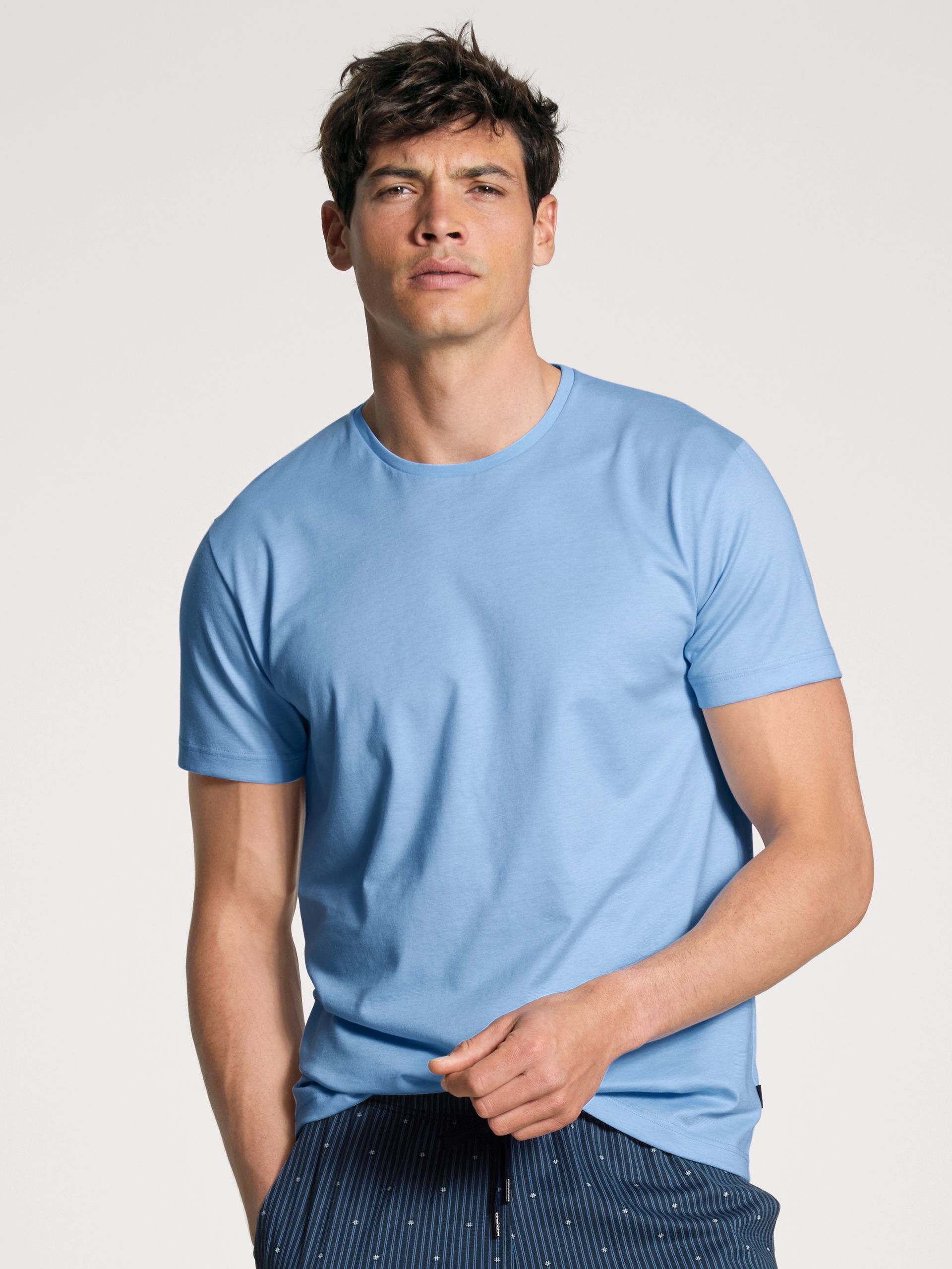 Le mannequin Homme porte le/la T-Shirt à manches courtes en 100% coton de couleur Bleu, Unicolore, de la série Remix Basic Sleep de CALIDA, Vue de face