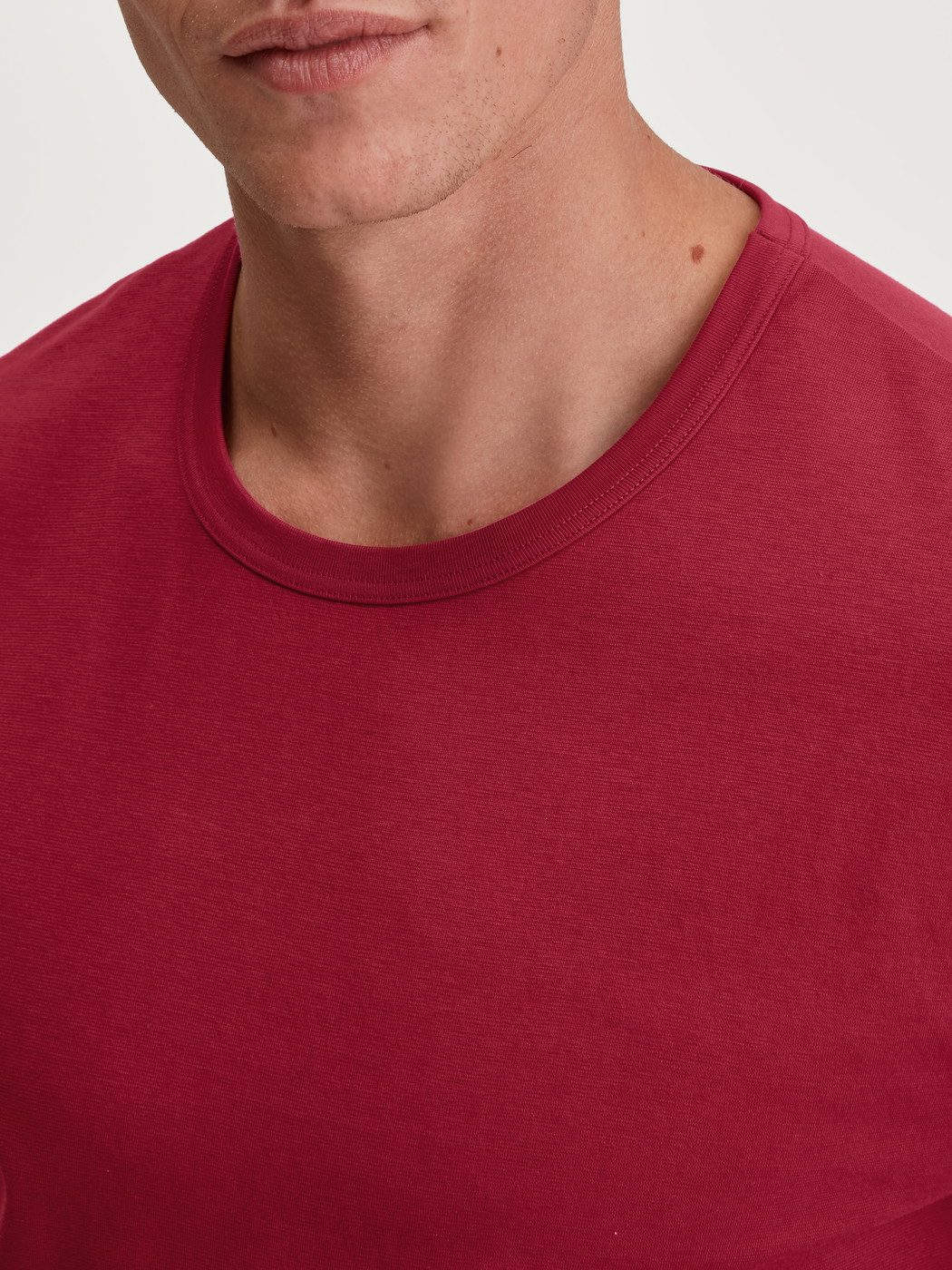 Herren-Model trägt Kurzarm-Shirt aus 100% Baumwolle in Rot, Einfarbig aus Serie Remix Basic Sleep von CALIDA, Detail