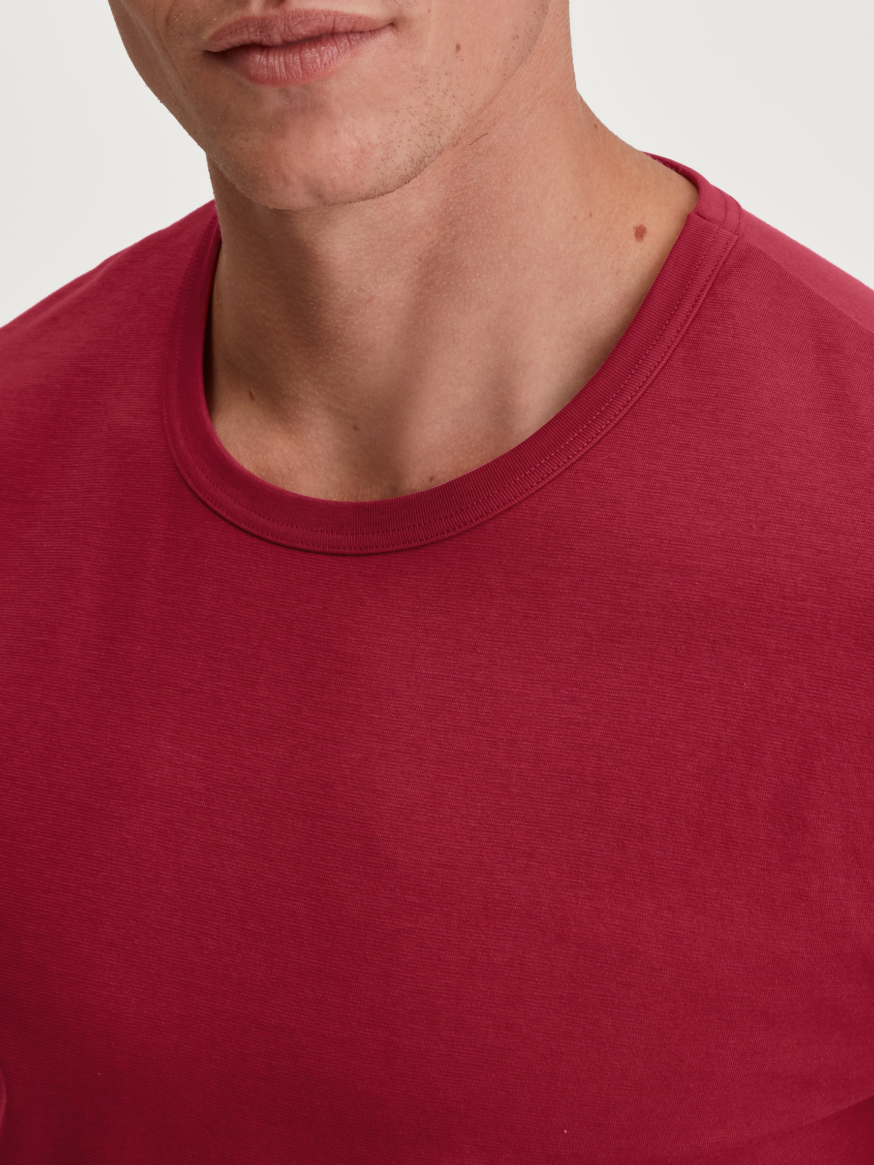 Men model is wearing Short-sleeved shirt made of 100% Cotton in Red, Unicoloured from the Remix Basic Sleep series by CALIDA, Detail