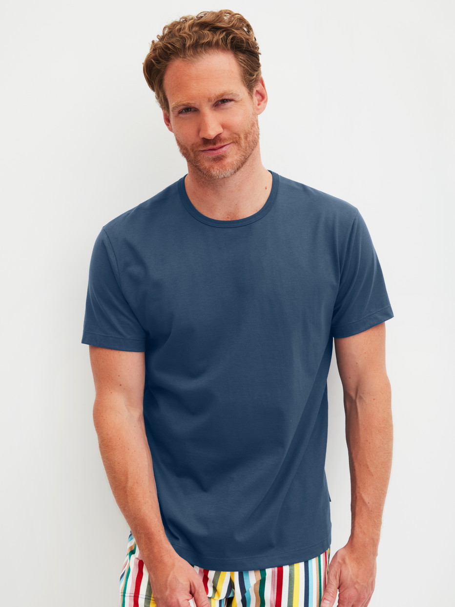 Herren-Model trägt Kurzarm-Shirt aus 100% Baumwolle in Blau, Einfarbig aus Serie RMX Sleep Holiday von CALIDA, Vorderansicht