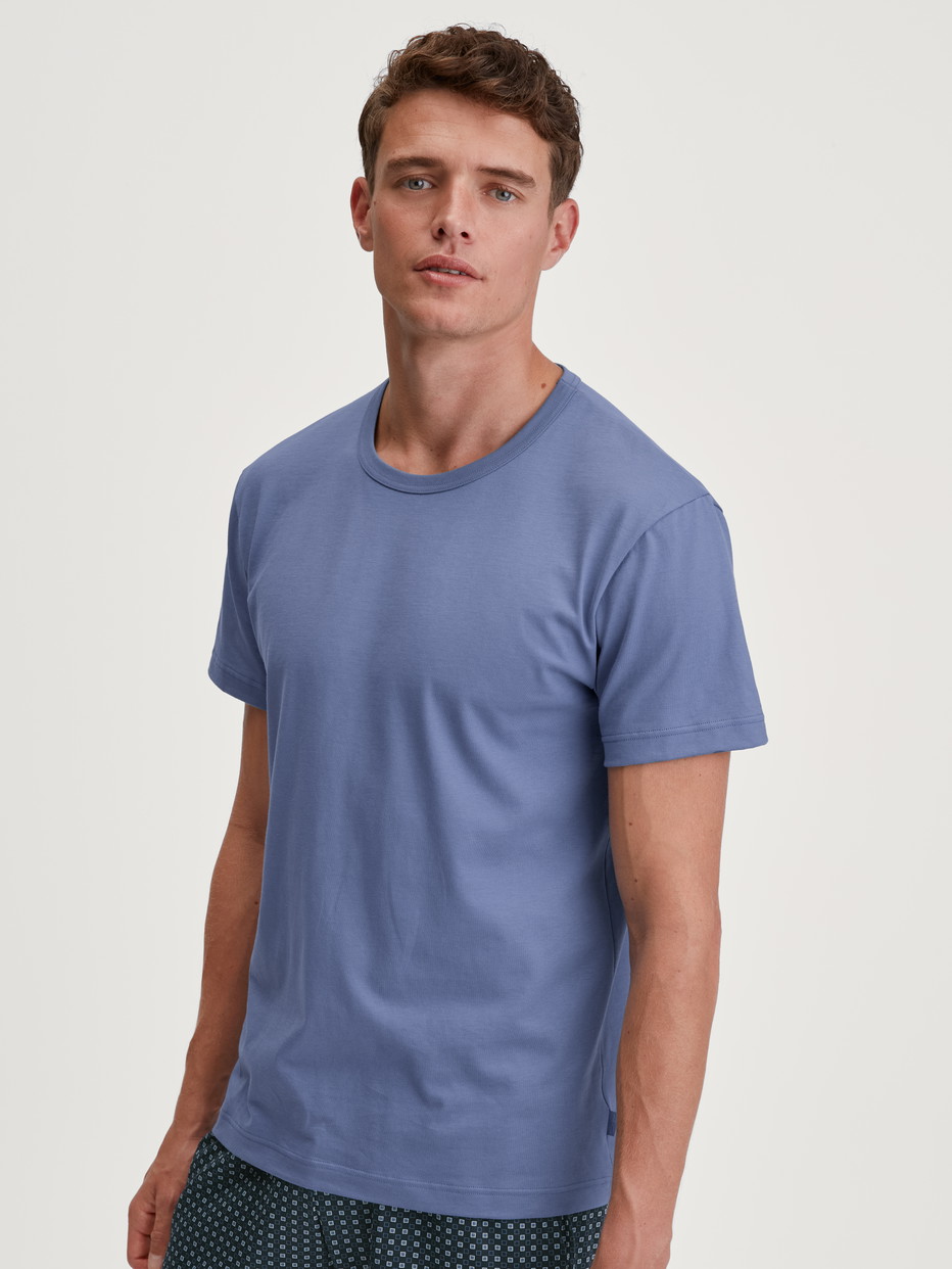 Herren-Model trägt Kurzarm-Shirt aus 100% Baumwolle in Blau, Einfarbig aus Serie Remix Basic Sleep von CALIDA, Vorderansicht