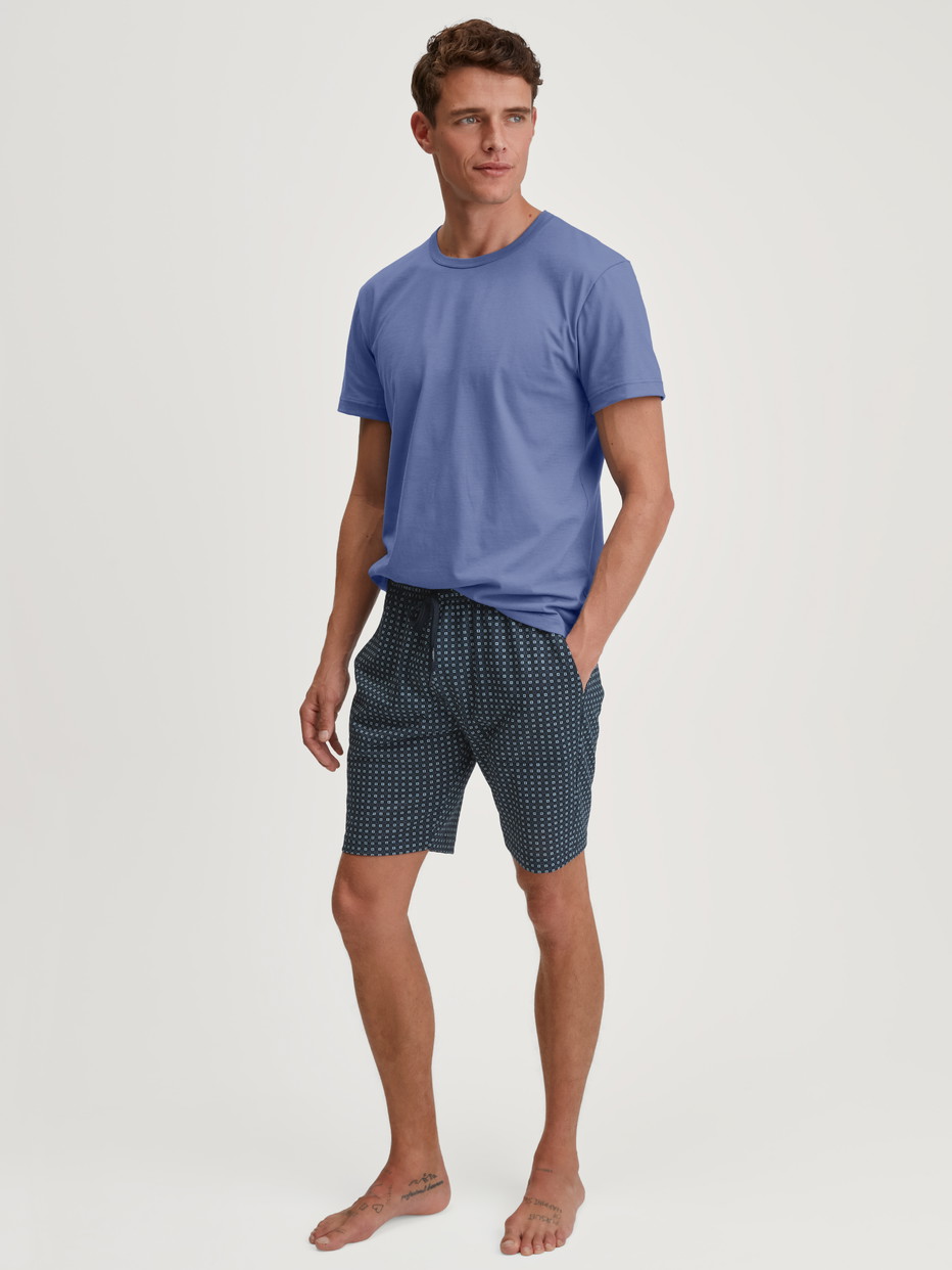 Herren-Model trägt Kurzarm-Shirt aus 100% Baumwolle in Blau, Einfarbig aus Serie Remix Basic Sleep von CALIDA, Outfit