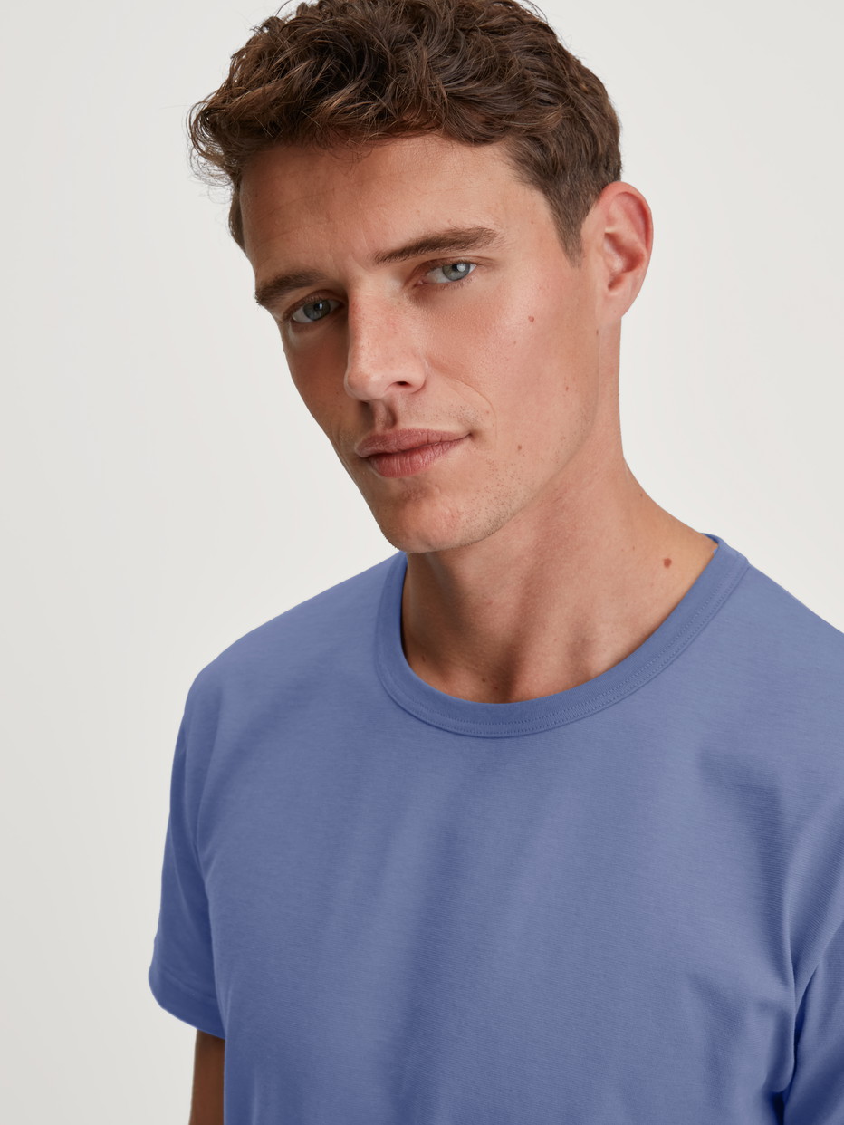 Herren-Model trägt Kurzarm-Shirt aus 100% Baumwolle in Blau, Einfarbig aus Serie Remix Basic Sleep von CALIDA, Detail
