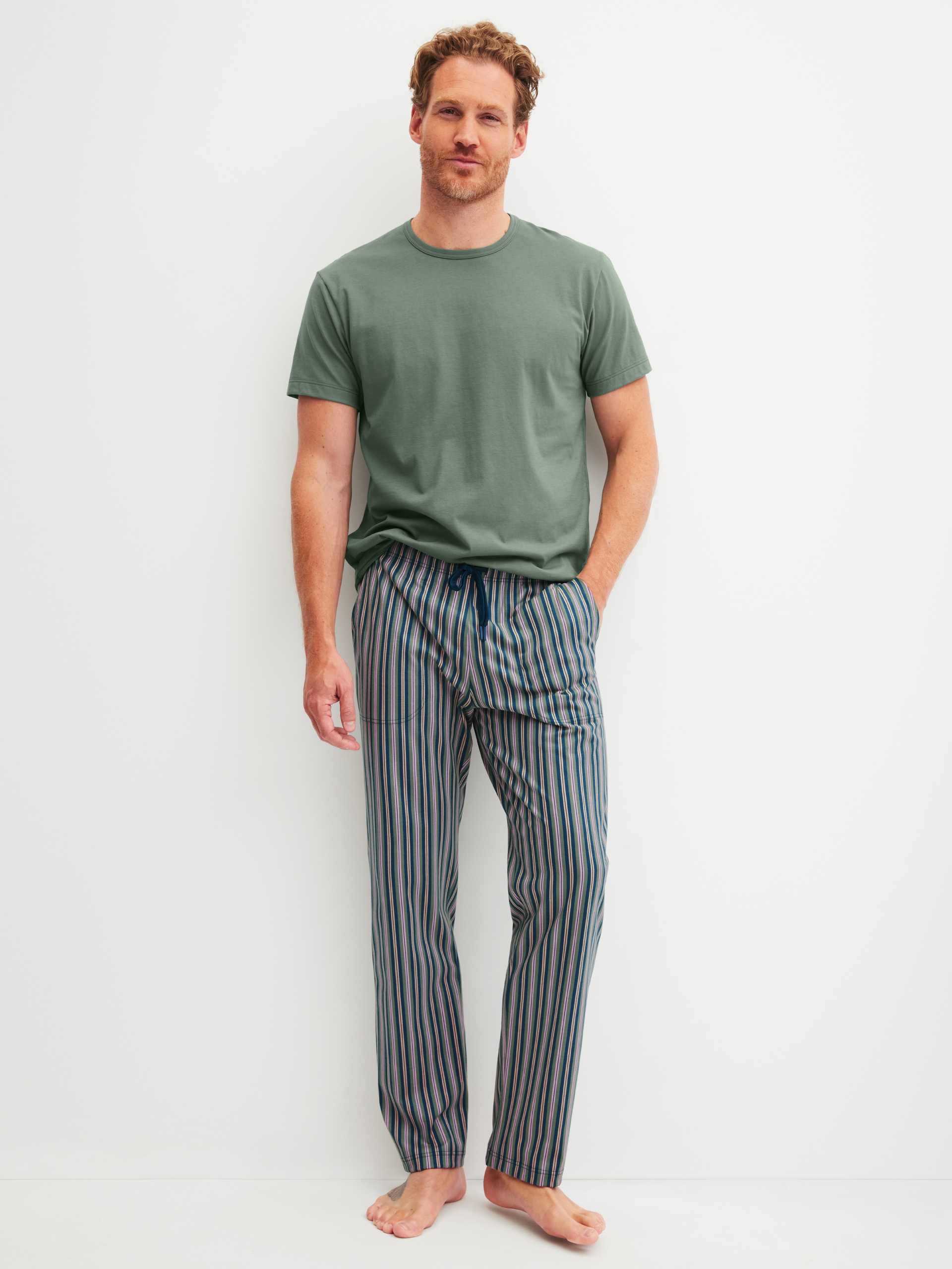 Herren-Model trägt Kurzarm-Shirt aus 100% Baumwolle in Grün, Einfarbig aus Serie RMX Sleep Leisure von CALIDA, Outfit