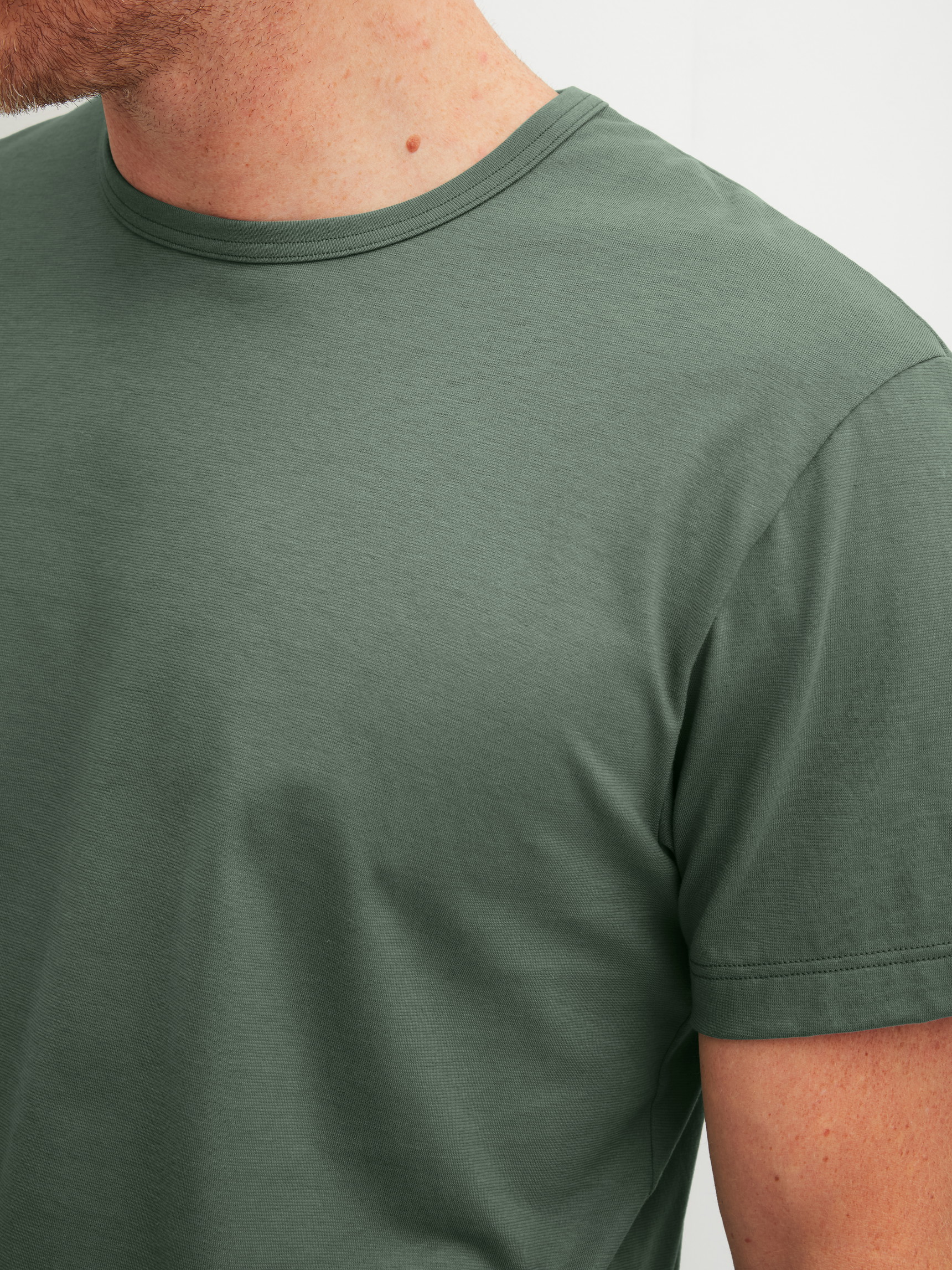 La modella / Il modello Uomo indossa Maglietta a maniche corte in 100% cotone di colore Verde, Tinta unita, della serie RMX Sleep Leisure di CALIDA, Dettaglio