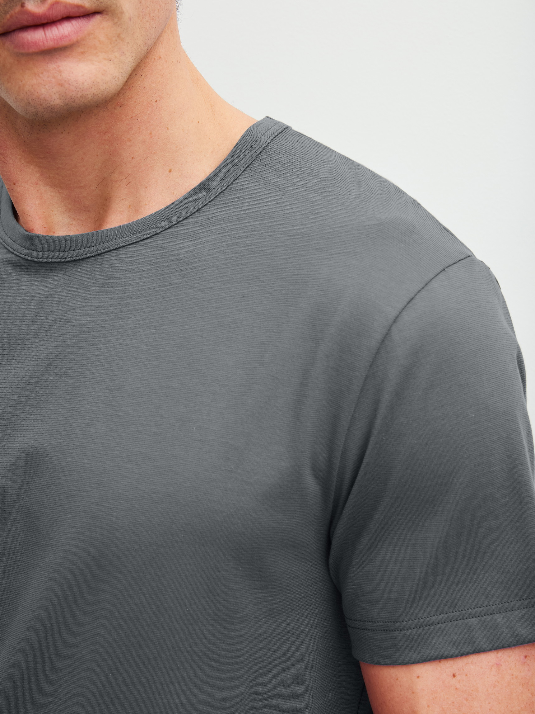 Herren-Model trägt Kurzarm-Shirt aus 100% Baumwolle in Grau, Einfarbig aus Serie RMX Sleep Leisure von CALIDA, Detail
