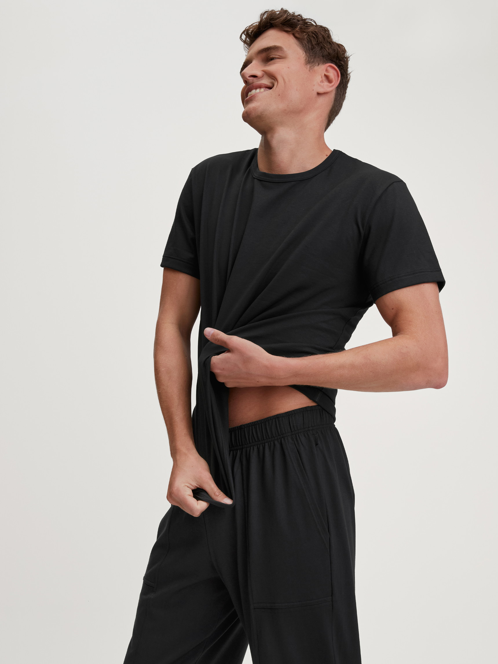 Herren-Model trägt Kurzarm-Shirt aus 100% Baumwolle in Schwarz, Einfarbig aus Serie RMX Sleep Leisure von CALIDA, Vorderansicht