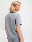 Women model is wearing Short-sleeved shirt with buttons made of 100% Cotton in Blue, Unicoloured from the Favourites Tiles series by CALIDA, Back view