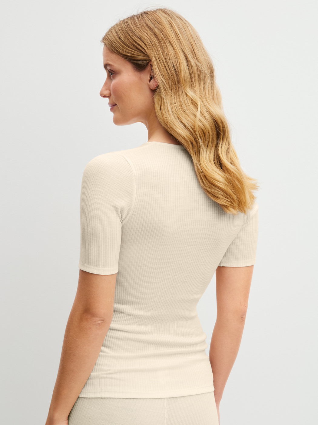 La modella / Il modello Donna indossa Maglietta a maniche corte in lana-seta in Lana di colore Beige, Tinta unita, della serie Silky Wool Soft di CALIDA, Vista posteriore