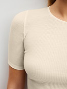 La modella / Il modello Donna indossa Maglietta a maniche corte in lana-seta in Lana di colore Beige, Tinta unita, della serie Silky Wool Soft di CALIDA, Dettaglio