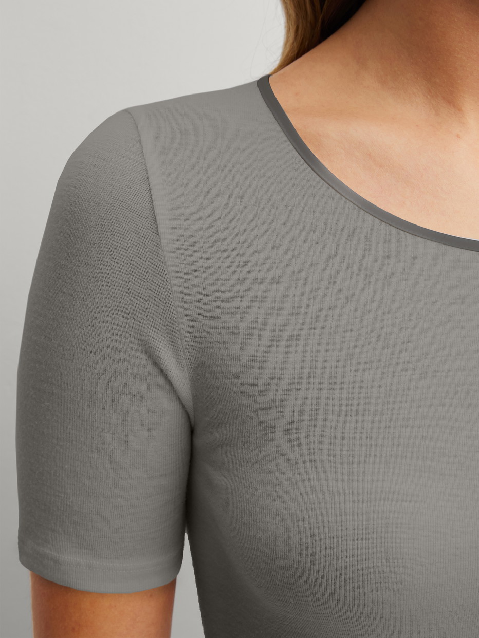 La modella / Il modello Donna indossa Maglietta a maniche corte in lana-seta in Lana di colore Grigio, Tinta unita, della serie True Confidence di CALIDA, Dettaglio