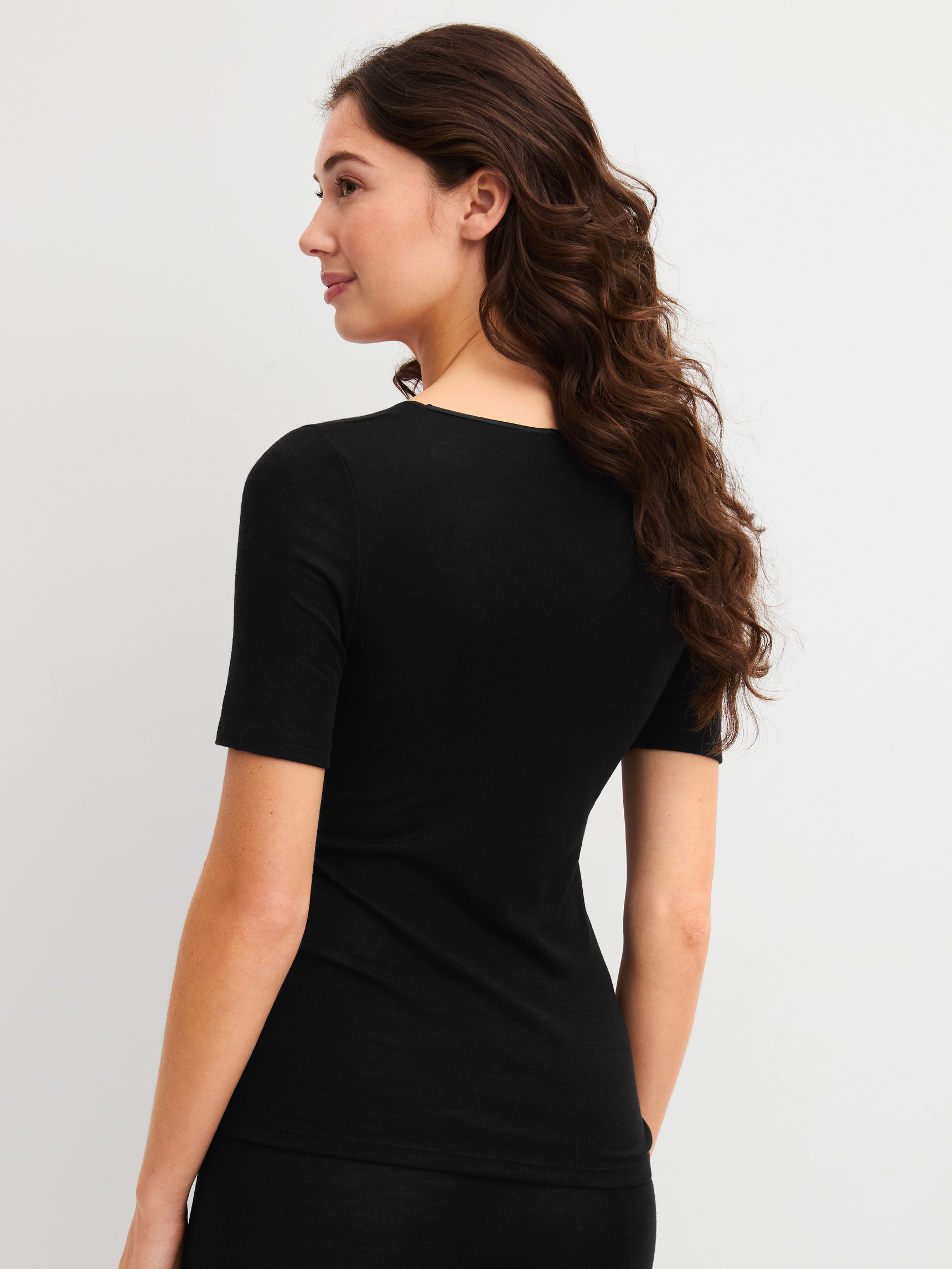 Damen-Model trägt Kurzarm-Shirt aus Wolle-Seide aus Wolle in Schwarz, Einfarbig aus Serie True Confidence von CALIDA, Rückansicht