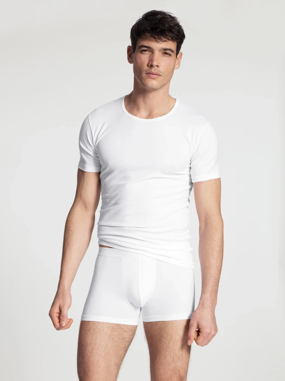 Men model is wearing T-Shirt, 2-Pack made of Cotton in White, Unicoloured from the Natural Benefit series by CALIDA, Front view, Outfit