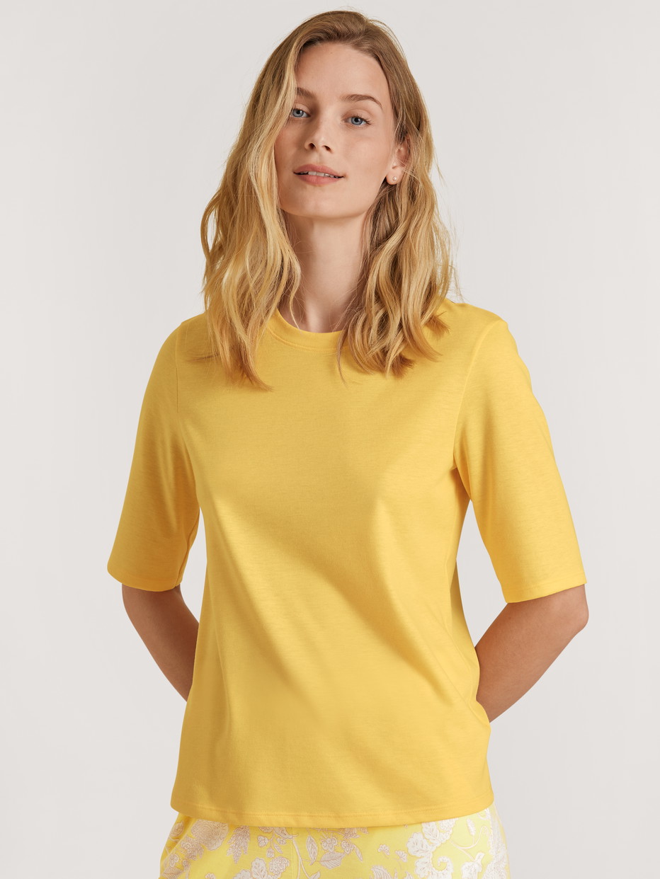 Damen-Model trägt Kurzarm-Shirt aus Modal in Gelb, Einfarbig aus Serie Favourites Light von CALIDA, Vorderansicht