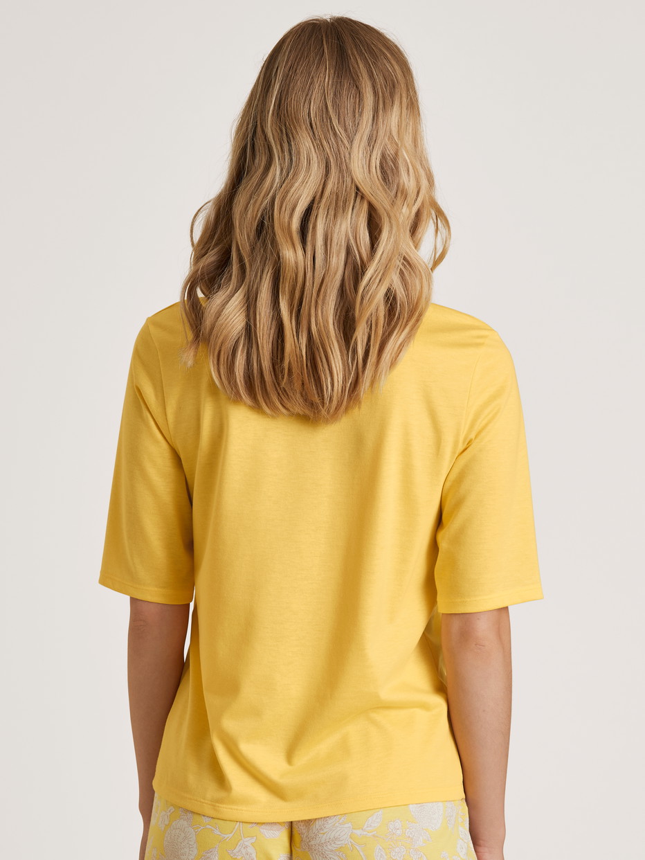 Damen-Model trägt Kurzarm-Shirt aus Modal in Gelb, Einfarbig aus Serie Favourites Light von CALIDA, Rückansicht